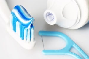 A toothbrush with toothpaste and flosser
